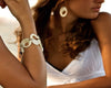 Two models wearing the bracelet and the earrings from the Re-circle collection